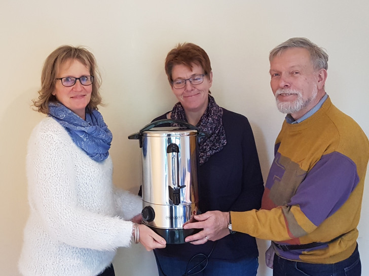 Barbara Gabriel (von links) überreicht die Glühwein-Töpfe an die Vertreter des Stadtteilnetzwerks Marion Köchy (Koordinatorin) und Rainer Jonas (Vorstand). Foto: WoBau 