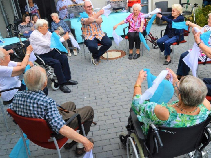 Mitarbeiter beim Sitztanz mit unseren Bewohnern sowie einen unserer Praktikanten beim Tanz mit einer Bewohnerin. Foto: Alloheim