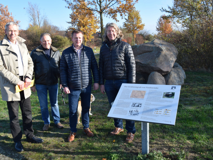 Stadtbaurat Kai-Uwe Hirschheide, Ortsratsmitglied Jochen Schröder, Stellvertretender Ortsbürgermeister Harald Hoppe und Ortsbürgermeister Hans-Georg Bachmann freuen sich über die wieder hergestellte Informationstafel. Foto: Stadt Wolfsburg.