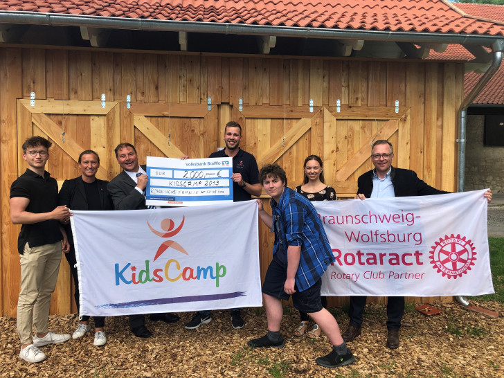 Mitglieder des Rotary Clubs und der Rotarischen Familien überreichen den Spendenscheck an Rotaract und das KidsCamp. Foto: Rotary Club Salzgitter/Wolfenbüttel