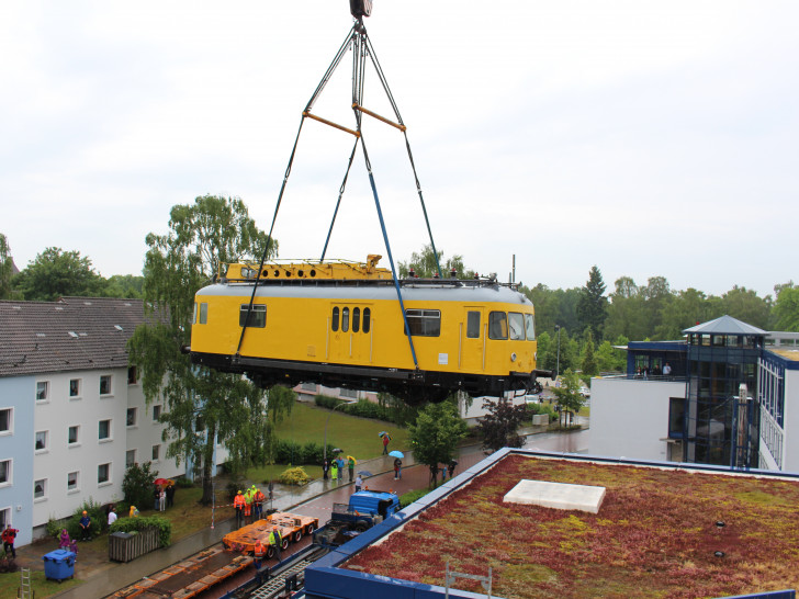 Ein 25 Tonnen schwerer Schienenbus wird über ein fünfstöckiges Gebäude gehoben. Foto: Max Förster