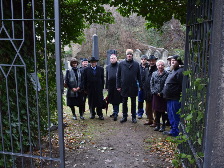 Die Projektbeteiligten freuen sich über das neue Metallgittertor, das auch in geschlossenem Zustand freien Blick auf den jüdischen Friedhof ermöglicht. Foto: Stadt Goslar