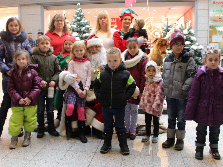 Maria-Theresia Schrader vom Mieterbeirat und Karina Karger vom Center-Management begrüßten zusammen mit vielen Kindern den Weihnachtsmann und seine Gehilfen. Foto: Alexander Dontscheff