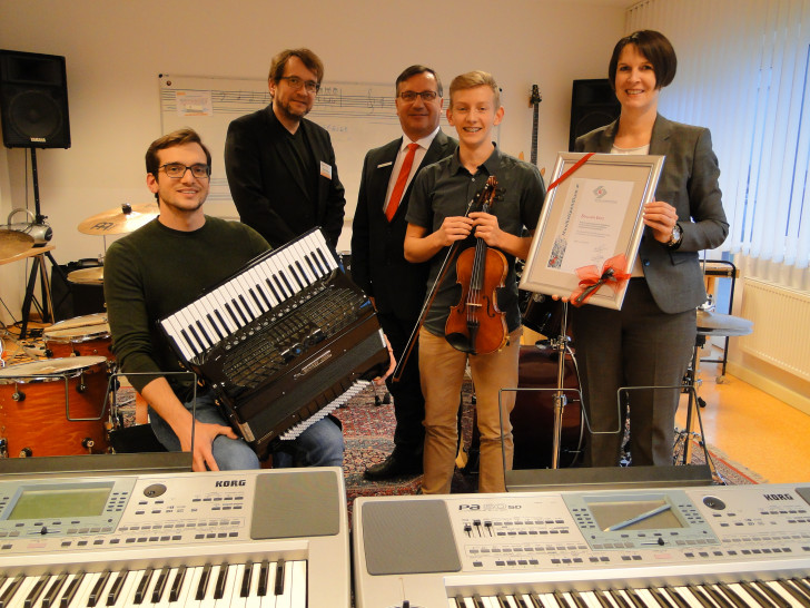 Umringt von Instrumenten fühlt sich Benjamin Enns (2.v.r.) am wohlsten: Von Silke Comberg und Jürgen Kröger, Vorstände der Kultur- und Sozialstiftung der Sparkasse Gifhorn-Wolfsburg, bekam er das Musikstipendium überreicht. Musiklehrer Nemanja Lukic (l.) und Musikschulleiter Peter Bönisch (2.v.r.) gratulierten. Foto: Sparkasse Gifhorn-Wolfsburg
