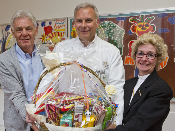 Renate Brandes und Ulrich Brandes überreichen Prof. Dr. Hans Georg Koch, Chefarzt der Klinik für Kinder- und Jugendmedizin, neben dem Geldscheck einen großen Korb gefüllt mit Leckereien für die kleinen sowie großen Patientinnen und Patienten der Kinderklinik. Bildnachweis: Klinikum/Jörg Scheibe
