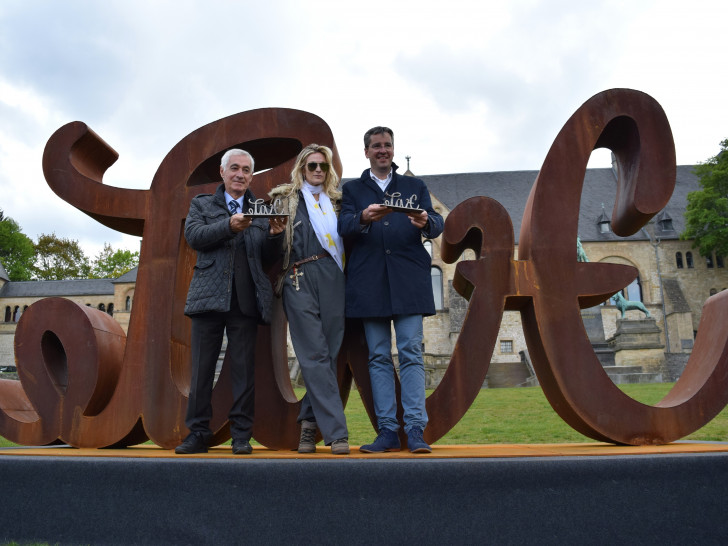 Goslars Oberbürgermeister Dr. Oliver Junk (von rechts), Künstlerin Mia Florentine Weiss und Bernard Lummeaux, stellvertretender Bürgermeister von Arcachon, präsentieren die Skulptur LOVE HATE vor der Kaiserpfalz. Foto: Stadt Goslar