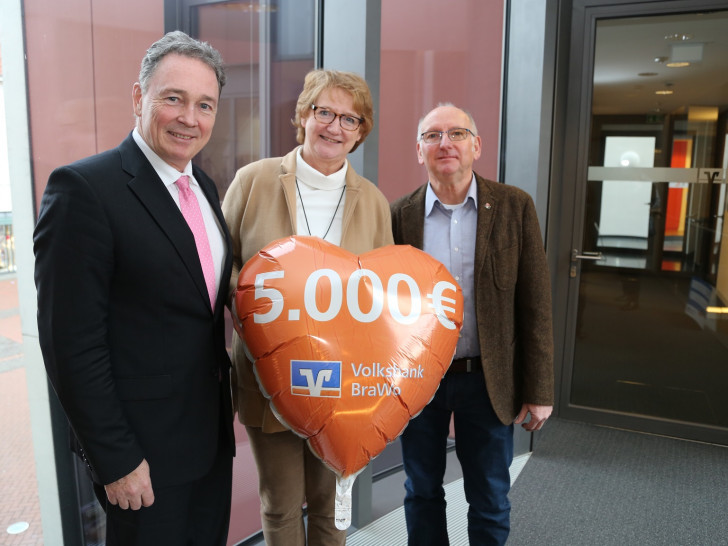 Ingrid Pahlmann, Vorstandsvorsitzende des Hospizvereins Gifhorn, und Vorstandsmitglied Heinrich Heins (re.), nehmen die Spende über 5.000 Euro von Thomas Fast, Leiter der Direktion Gifhorn der Volksbank BraWo, entgegen. Foto: Volksbank BraWo