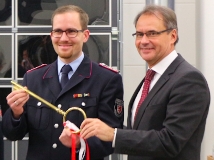 Oberbürgermeister Ulrich Markurth übergibt einen symbolischen Schlüssel an Ortsbrandmeister Dennis Kelpen. Foto: Robert Braumann 