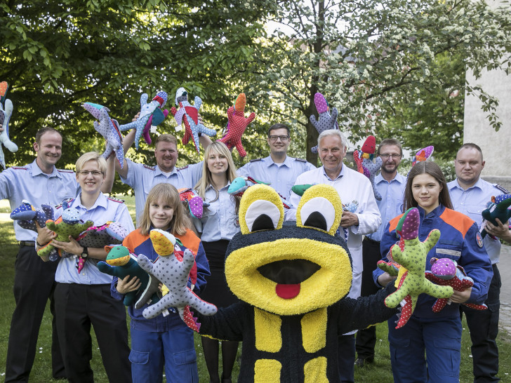 Überbrachten Mut- und Kraftdrachen: Mitglieder der Jugendfeuerwehr Thune zusammen mit ihrem Maskottchen Flori und Chefarzt Prof. Dr. Hans Georg Koch. Foto: Klinikum Braunschweig / Peter Sierigk