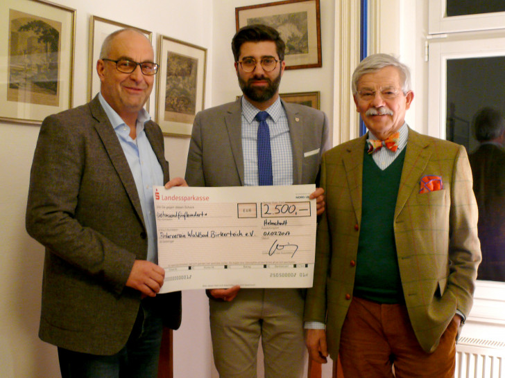 Martin Lehmann nimmt für den Waldbad-Förderverein den symbolischen Scheck von den Rechtsanwälten Sebastian Gutt und Christian Sticherling entgegen. Foto: Privat