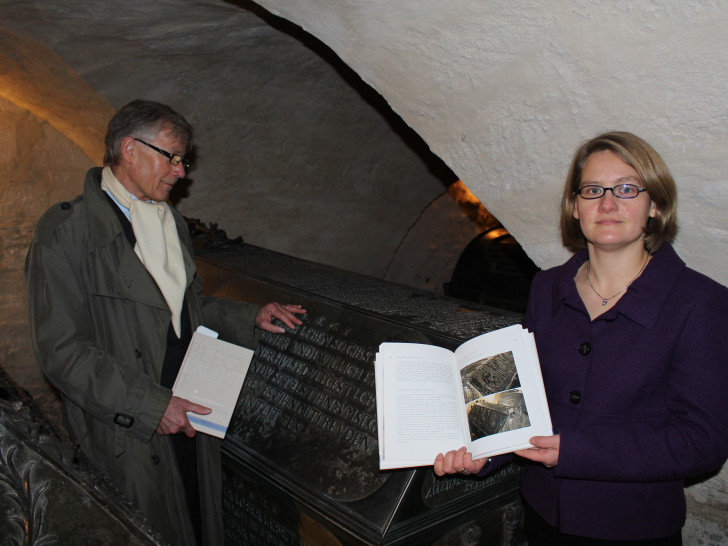 Herausgeber Prof. Dr. Christoph Helm und Pfarrerin Ina Naumann-Seifert vor einem Sarkophag in der Welfengruft. Foto: Jan Borner