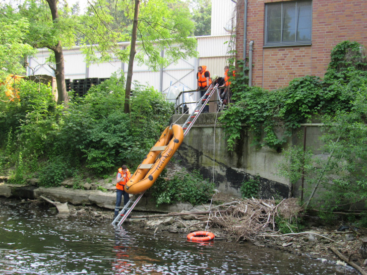 Das Schlauchboot wird am Hang eines offenen Gewässers zu Wasser gebracht. Foto: Feuerwehr