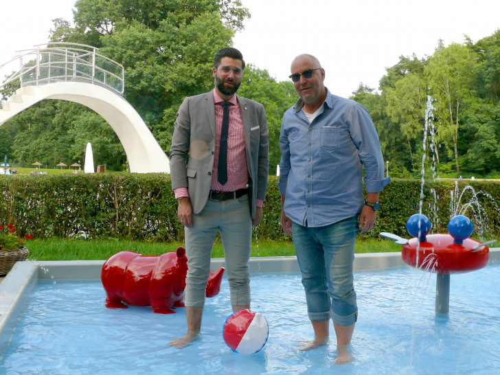 Rechtsanwalt Sebastian Gutt und Martin Lehmann vom Waldbad-Förderverein (v.li.) tauchen ihre Füße ins neue Babybecken, das noch mit einem Sonnenschutz versehen werden soll. Foto: Kanzlei Sticherling Simon & Partner