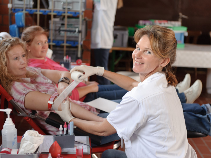Eine Helferin des DRK-Blutspendedienstes und eine Spenderin während der Blutspende. Foto: DRK