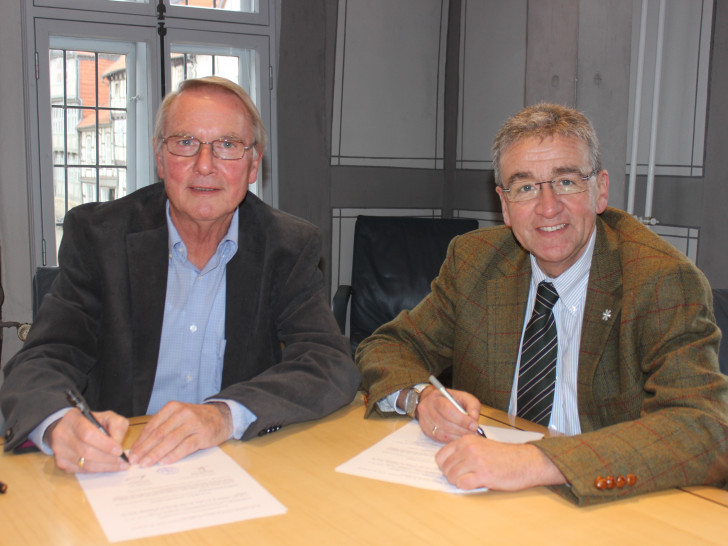 Heimatstiftungs-Vorsitzender Axel Gummert und Bürgermeister Thomas Pink unterzeichnen den Vertrag, der die Mittagsverpflegung in den Kitas sichert. Foto: Anke Donner 