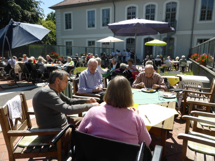 Die Bewohner und Gäste des Grillfestes auf der Brücke der Seniorenbetreuung Schloß Schliestedt. Im Hintergrund der Grillstand der hauseigenen Küche. Foto: Privat