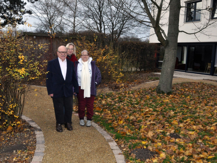  Anja Schildener (Mitte) dreht zusammen mit den Bewohnern Hans-Dieter (links) und Sonja die erste Runde im Sinnesgarten vor dem Lebenshilfe-Wohnheim. Foto: Lebenshilfe