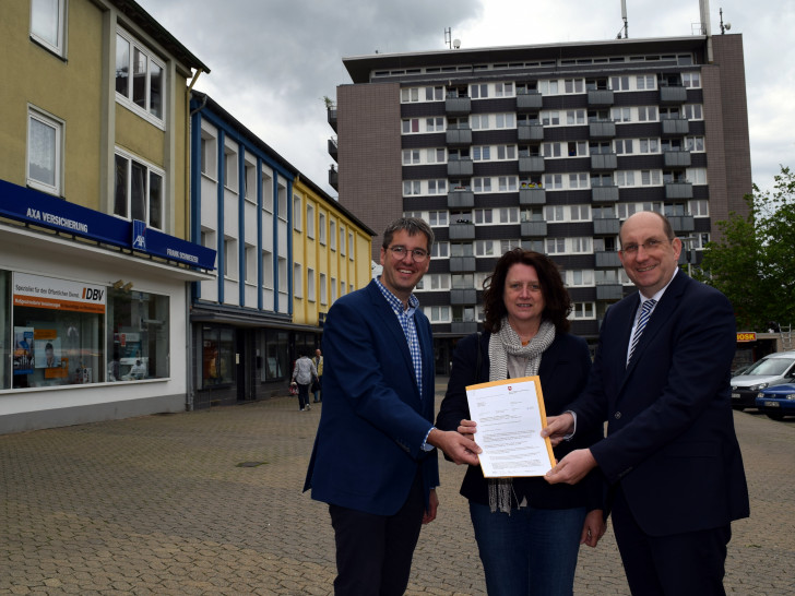 Dr. Oliver Junk (links) und Marion Siegmeier nehmen auf dem Goslarer
Marktplatz den Brief von Matthias Wunderling-Weilbier entgegen, der die Aufnahme in das
Förderprogramm „Soziale Stadt“ verkündet. Foto: Stadt Goslar