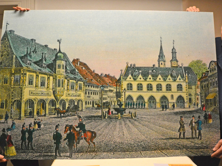 Ursula und Jörg-Utz Hapke vom Museumsverein Goslar zeigen eine colorierte und stark vergrößerte Zeichnung vom Goslarer Marktplatz aus der Feder von Wilhelm Ripe. Foto: Museumsverein Goslar e.V.