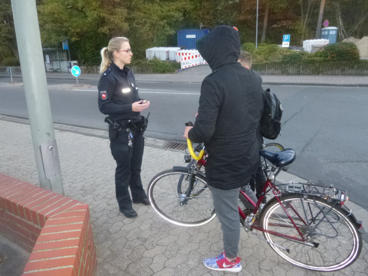 Die Einsatzleiterin, Polizeikommissarin Sarah Reichardt, bei einem erzieherischen Gespräch mit zwei ertappten Radfahrern. Foto: Polizeiinspektion Gifhorn