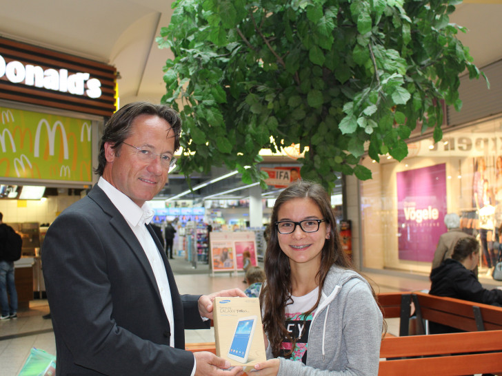 Sven Hess vom Center Management überreicht Kristin Ahrens ihr neues Tablet. Foto: Jan Borner