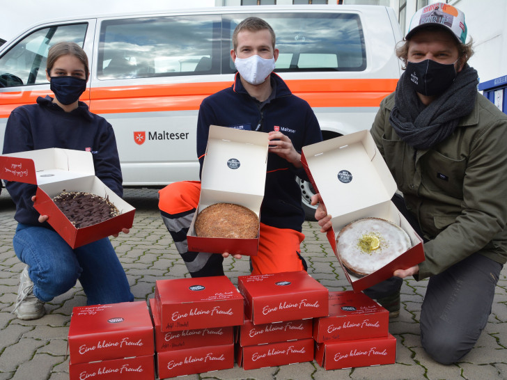 Fabian Haars, Vorstandsvorsitzender von „Cheer’s Kitchen“ (rechts) mit den Maltesern Lea Klipan (links) vom Hausnotruf und Rettungssanitäter Lukas Schaller.