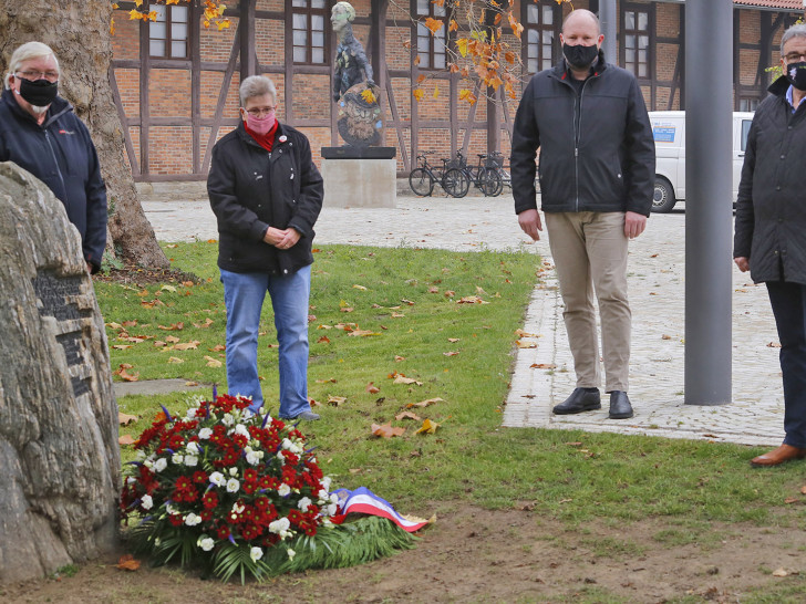 Michael Sandte und Sabine Resch-Hoppstock (Bündnis gegen Rechtsextremismus), Pfarrer Matthias Eggers und Bürgermeister Thomas Pink bei der Kranzniederlegeung.