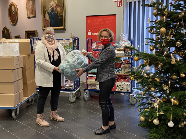 Anja Wiegand (re.) aus dem Orga-Team des Weihnachtswünschebaums übergibt die Spenden an Heike Malek vom Parkbank e.V..