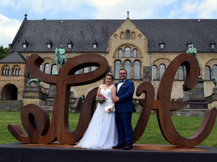 Ein Brautpaar posiert an der LoveHate-Skulptur vor der Kaiserpfalz.