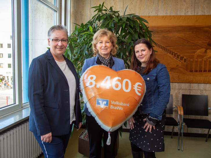 Claudia Kayser (Volksbank BraWo, Mitte) übergibt eine Spende über 8.460 Euro zugunsten des Projektes „Gemeinsam wachsen“ an Stadträtin Iris Bothe und Katharina Varga von der Stadt Wolfsburg.