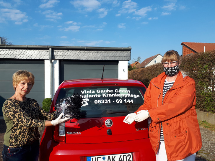 Monika Trogisch übergibt genähte Masken an Conny Andres, Pflegekraft beim ambulanten Pflegedienst Viola Gaube. Von links: Monika Trogisch, Conny Andres.