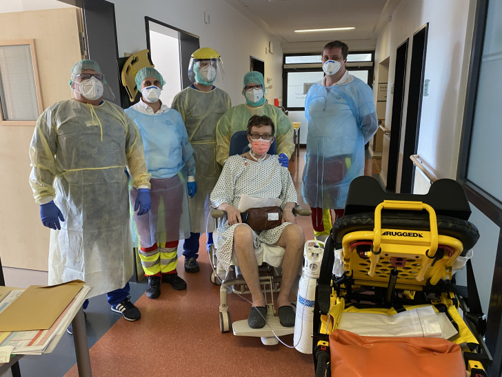 Freuen sich mit dem Patienten: Mitarbeiter, Pflegekräfte der Harzklinik Goslar (in gelber Schutzkleidung),  mit zwei Sanitätern des Rettungswagens, die den Patienten zurück nach Zwolle/ Niederlande bringen.