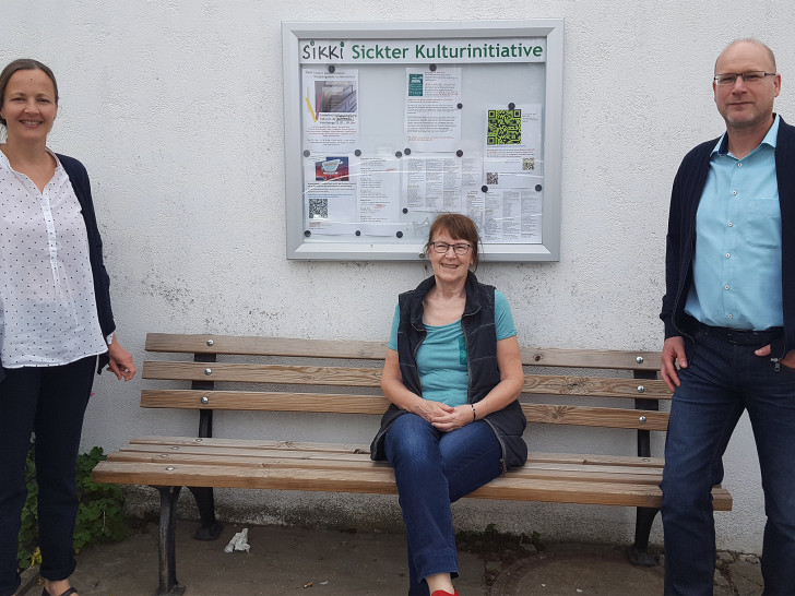 Claudia Busch (Konzerte) und Annegrit Helke (Ausstellungen, Lesungen) freuen sich zusammen mit dem neuen Sickter Bürgermeister Ingo Geisler über den SIKKI-Schaukasten. Zum SIKKI -Team gehört noch Susanne Busch (Konzerte).