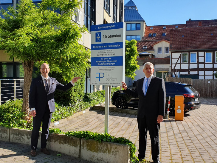 Von links: Stefan Honrath und Rainer Falkenhagen von der Volksbank BraWo weisen auf die neue Parkscheibenpflicht für die Nutzung des Volksbank-Parkplatzes am Windmühlenwall hin.