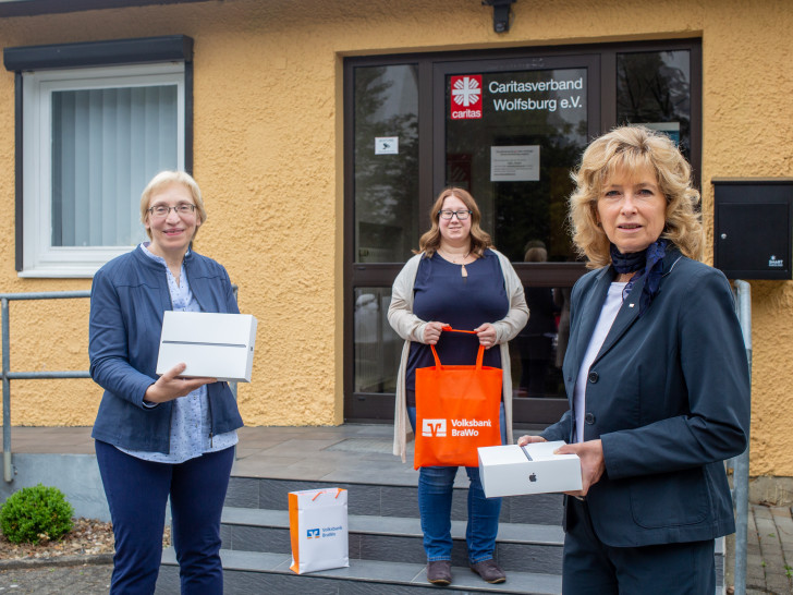 Claudia Kayser, Leiterin der Direktion von der Volksbank BraWo (rechts) überreicht vier iPads für die Seniorenarbeit an Barbara-Maria Cromberg (Vorständin) und Annika Scharenberg (Koordinatorin der Seniorenarbeit) vom Wolfsburger Caritasverband.