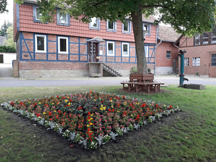 Der Pumpenplatz lädt mit historischer Pumpe, Brunnen und Rundbank und Blumenbeet zum Verweilen ein.