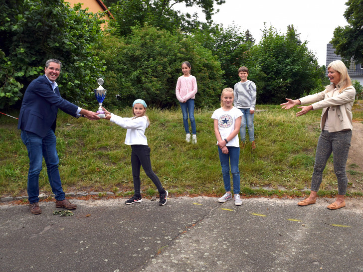 In Hahndorf nehmen Schulleiterin Astrid Nitsch (von rechts) und ihre Schützlinge Leevi, Luise, Liesa und Merle den Pokal von Oberbürgermeister Dr. Oliver Junk stellvertretend für ihre Klassenkameradinnen und -kameraden der 3. und 4. Klassen entgegen.