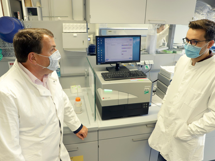 Promovend Alexander Heinz (r.) erklärt Axel Burghardt, Geschäftsführer des Klinikums Wolfenbüttel, wie die Tests auf Covid-19 im Labor des BRICS ausgewertet werden. 