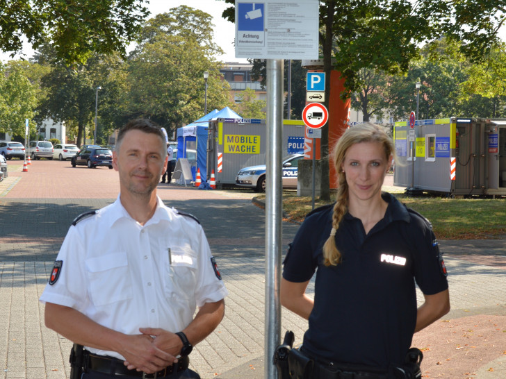 Matthias Pintak (Pressesprecher der Polizeiinspektion Salzgitter/Peine/Wolfenbüttel) und Anne Goder vom Polizeikommissariat Peine vor einem der Schilder, die auf die Videoüberwachung hinweisen.