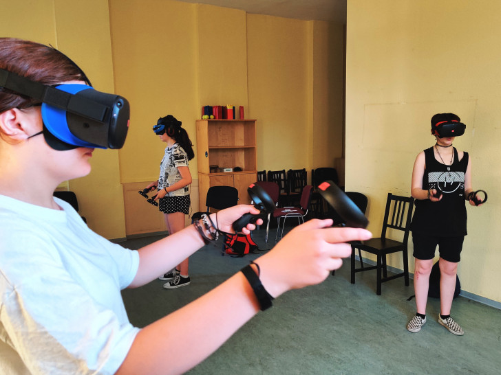 Lara, Julia und Anna (v. l.) spielen ein Virtual Reality-Game.