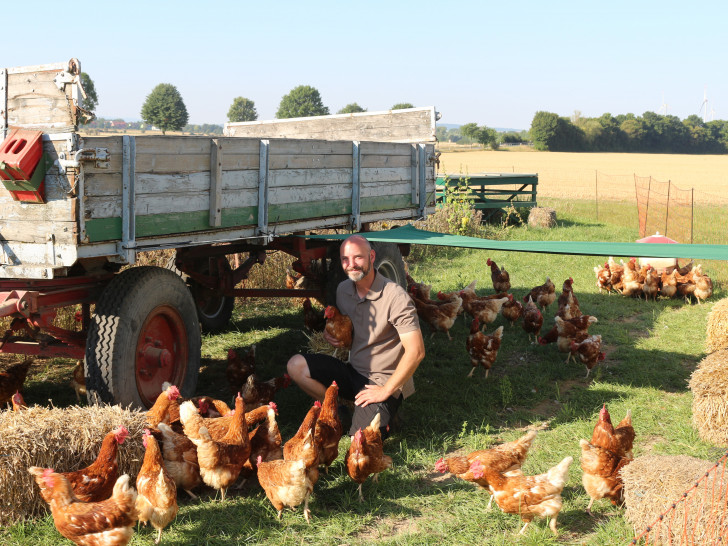 Florian Harms zwischen seinen Hühnern. Über 400 Hühner halten er und seine Frau in zwei Mobilställen. Ein dritter sei bereits in Planung.