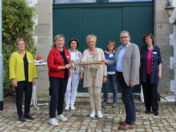 Dagmar Ammon (Vorsitzende Hospizverein Wolfenbüttel) nimmt im Beisein der Vereinsmitglieder von Bürgermeister Thomas Pink den symbolischen Schlüssel für das Gutshaus entgegen. 