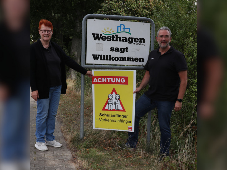 Dr. Christa Westphal-Schmidt, stellvertretende Ortsbürgermeisterin von Westhagen, und Matthias Bussler, Vorsitzender des SPD-Ortsvereins Westhagen, mit einem SPD-Plakat zum Schulanfang. 