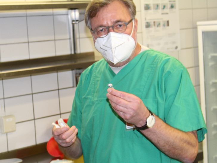 Der medizinische Leiter des Impfzentrums Prof. Dr. Karl Wessel erklärt, wie der Impfstoff angerührt werden muss.