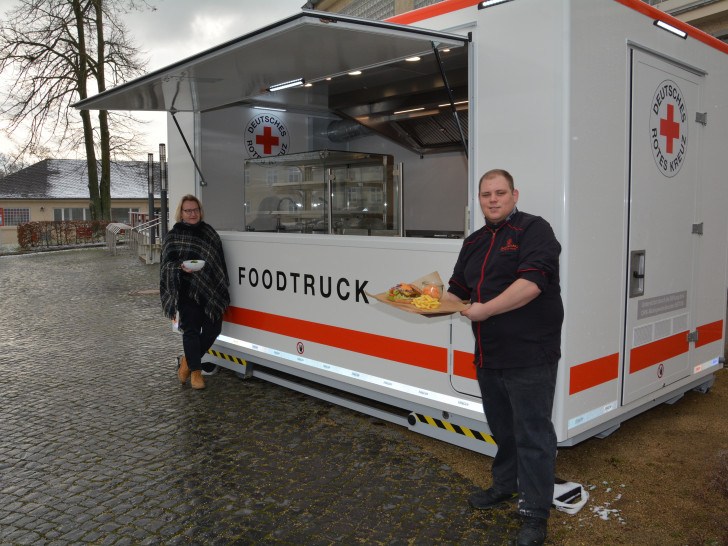 Corina Bornecke (links) und Sascha Bartels mit dem Klassiker, dem Burger, vor dem neuen Foodtruck.