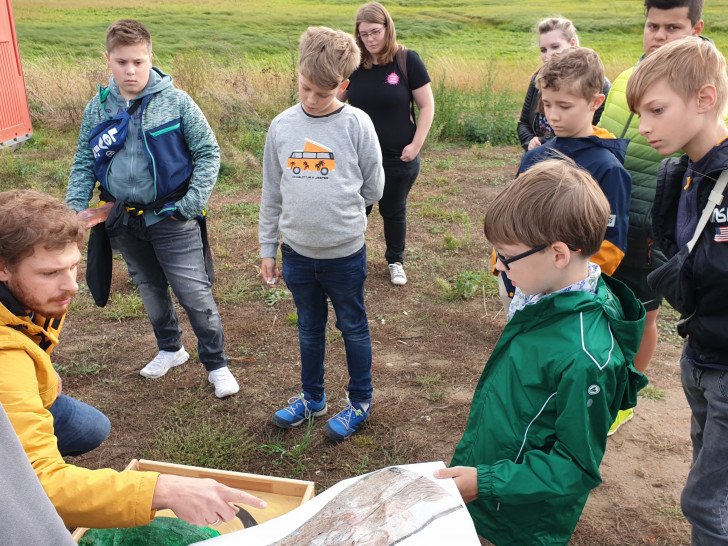 Der Kinderbeirat Wolfsburg mit Daniel Pollok beim Besuch der archäologischen Grabung am Sonnenkamp.