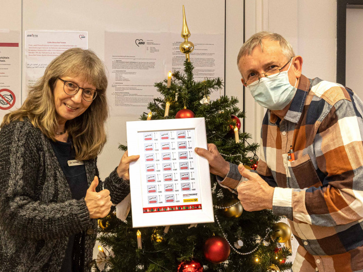 Birgit Hynek bekommt die Sondermarken von Rudolf Karliczek übergeben.