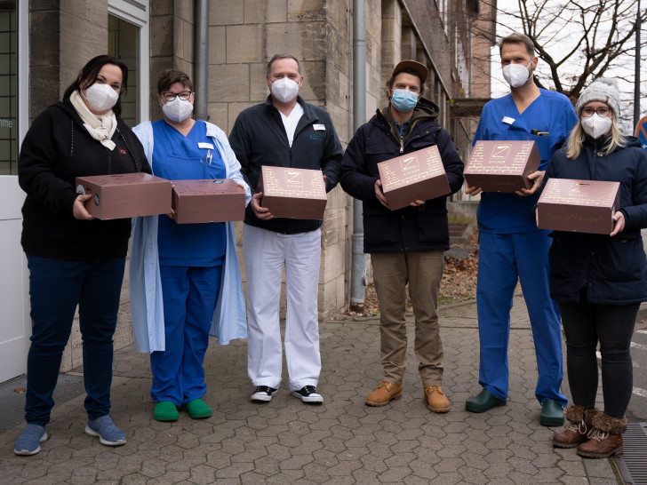 Manuela Soika (li.) und Jennifer Rieck (re.) überreichten stellvertretend für CGI Deutschland gemeinsam mit Fabian Haars (3. v. re.), Cheer’s Kitchen, die Menüboxen an die Stationsleitungen aller COVID-Stationen des Städtischen Klinikums Braunschweig: Anja Wagner-Brandt, Carsten Conrad und Thomas Hanhus (blauer Kasak). 