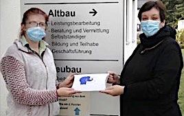 Frau W. (li.) bei der Übergabe des Geschenkpäckchens durch ihre Arbeitsvermittlerin.