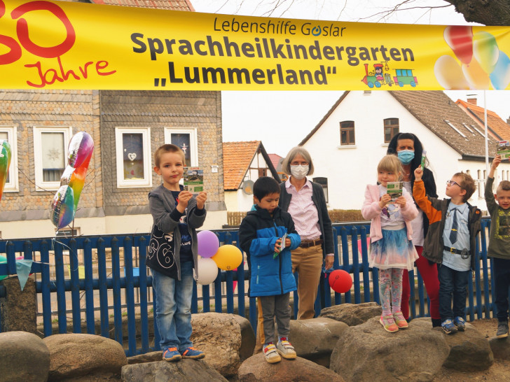 Leiterin Maria Lindemann und Erzieherin Marion Heldt freuen sich mit den Kindern der blauen Gruppe über das Geschenk der Bürgerstiftung: Wanderpässe zum Stempelwandern.